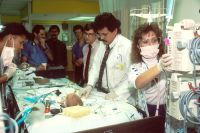 Infant baby Doctors Examine Infant. A group of doctors examine an infant in the intensive care unit (ICU). Photographer Bill Branson  hospital,health,intensive
