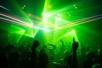 club nightlife People dancing in a club while a DJ is playing electronic music with lasers 