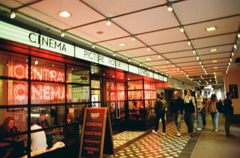 Cinema conflict Red neon cinema signs glow inside an arcade as people walk past a Picturehouse cafe bar.