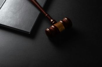 Courtroom exhumation Judge gavel and book on black background. Law and justice concept 