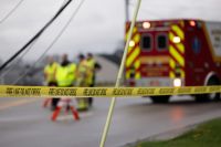 Violence Incident Emergency personnel behind “FIRE LINE DO NOT CROSS” tape near an ambulance. 
