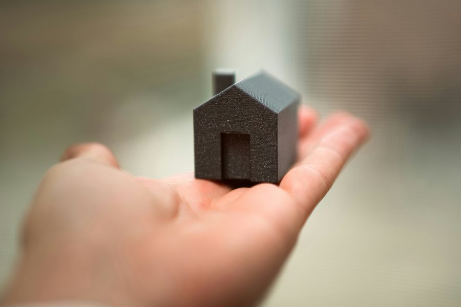 Housing issues hand holding house real estate market purchase property selection 