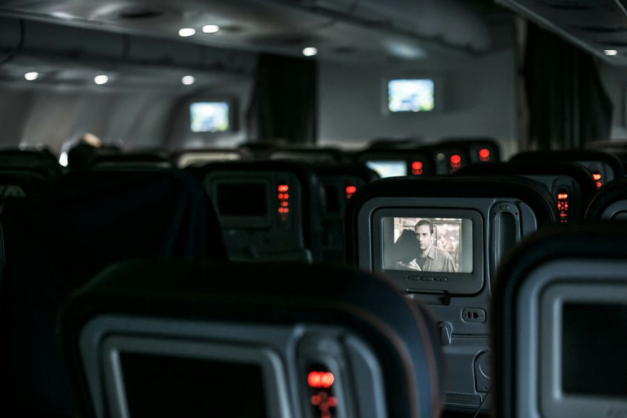 Airport air A plane's interior, with empty seats and a movie on a screen. plane,airport,airplane
