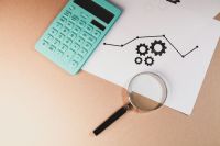 Finance audit magnifying glass on the desk with money. top view 
