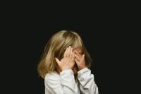 child GIrl covering her face 