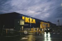 Ikea construction IKEA photographed on a rainy evening in Melbourne, Australia, with illuminated signage reflecting across the wet pavement and a moody film aesthetic. 