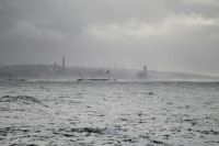 Storm Monica A flag billows dramatically against the backdrop of turbulent pacific seas on the California coast. united states,santa monica,santa monica pier