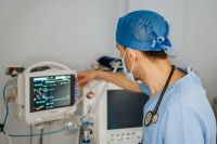 Patient data In this photo, a dedicated doctor carefully handles a vital signs monitor, using advanced technology to monitor and track crucial health indicators. With unwavering focus, the doctor ensures accurate data for effective medical care. 