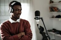 Technology Pioneer African male voice over artist recording a voice-over script with a condenser and Pioneer exclusive headphones. pioneer exclusive headphone,entertainment,online