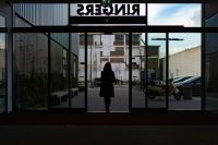 Transition Girl walks out of a public building door,grey,inside