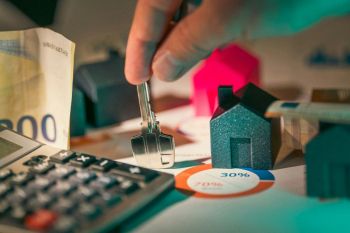 Home ownership Housing investment financing prices. Hand holding key to new house door . 