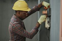 Occupations Portrait of a black man architect at a building site looking at camera. Confident civil engineering wearing a hardhat and eye goggles. Successful mature civil engineer at a construction site with open male,person,nigeria