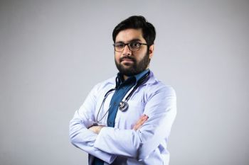 Doctor salary A doctor wearing stethoscope and medical coat with corner pose