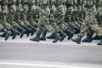 military security Soldiers dressed in army camouflage march in formation. 
