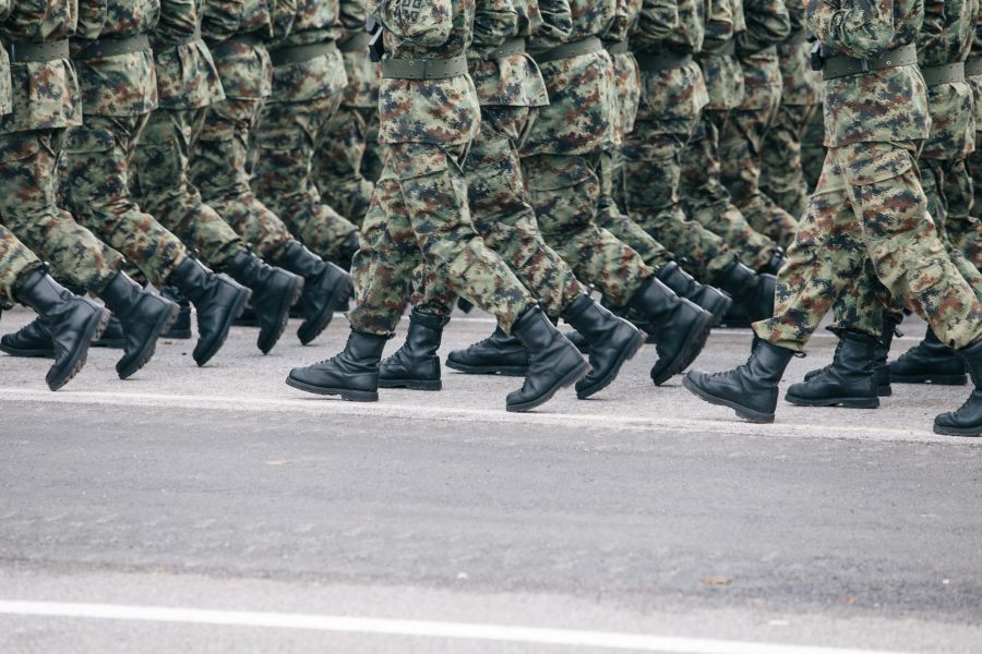 military security Soldiers dressed in army camouflage march in formation. 