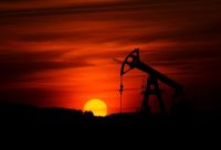Oil trade Pump-jack mining crude oil with the sunset 