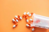 Prescription Prescription drugs on an orange background with a pill bottle. Orange pills.  