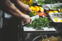 vegetarian chef Greens on a cutting board, and a Nice Knife and Lemons on the cutting board in the background 