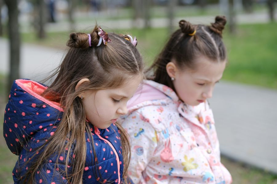 Regrets Remorse Emotional scene of two adorable girls sitting pensively on a bench, expressing sadness and guilt. The introspective mood of remorseful children, showcasing their emotional connections and regretful innocence remorseful state,children's guilt,pensive children