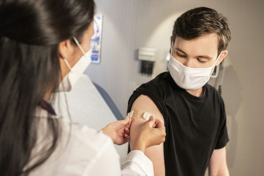 Vaccination In this 2020 photograph, captured inside a clinical setting, a health care provider places a bandage on the injection site of a patient, who just received an influenza vaccine. The best way to prevent seasonal flu, is to get vaccinated every year. Centers for Disease Control and Prevention (CDC) recommends everyone 6-months of age and older get a flu vaccine every season. wellness,covid19,facemask