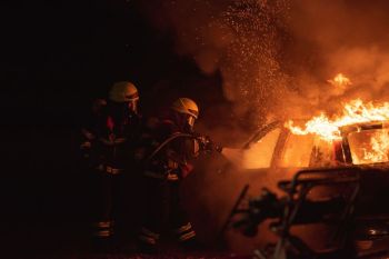 Firefighters Fire Two firefighters fighting a heavy car fire with water