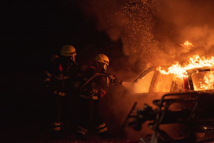 Firefighters Fire Two firefighters fighting a heavy car fire with water 