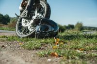accident motorcycle Endurohelm auf grüner Wiese am Vorderrad eines Scramblers // Enduro helmet on a green field on the front wheel on a scrambler 