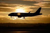 Airplane Gold Airliner landing in Zurich with wonderfully golden sunset backlight. 