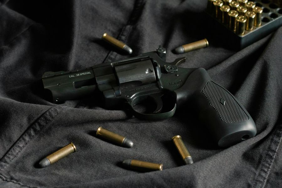 shooting violence A black revolver on black cloth, with ammunition 