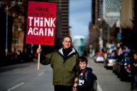 family protest A man and his son, peacefully protest the election of Donald J. Trump with a home-made sign that reads: Make America Think Again. 