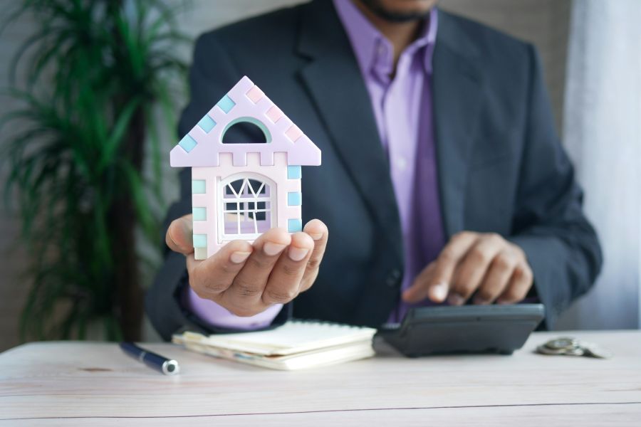 property tax  the concept of finance concept , man holding house in hand . 