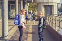 school health a girl and a boy with backpacks go to school in the morning 