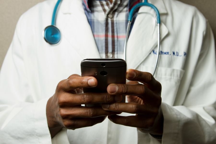 Health care Doctor Holding Cell Phone. Cell phones and other kinds of mobile devices and communications technologies are of increasing importance in the delivery of health care. Photographer Daniel Sone   