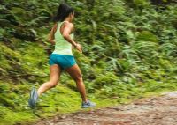 Jogging female runner on trail in the forest  